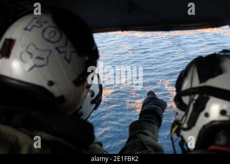 PAZIFISCHER OZEAN (13. März 2011) Marineluftcrewmen, die dem Black Knights of Helicopter Anti-Submarine Squadron (HS) 4 zugewiesen wurden, untersuchen Trümmer, die im Pazifischen Ozean von einem Erdbeben der Stärke 8.9 und dem darauf folgenden Tsunami driften, der Nordjapan traf. Schiffe und Flugzeuge der Ronald Reagan Carrier Strike Group suchen in den Küstengewässern bei Sendai, Japan, nach Überlebenden. Foto von NVNS via ABACAPRESS.COM Stockfoto