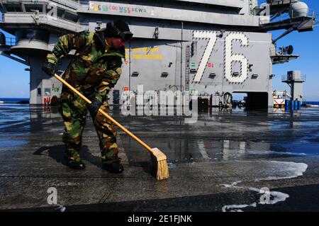 Aviation Boatswain's Mate (Handling) 3rd Class Ashton Hemphill schrubbt das Flugdeck des Flugzeugträgers USS Ronald Reagan (CVN 76) während einer Gegenmassespülung. Ronald Reagan ist vor der japanischen Küste und leistet humanitäre Hilfe, wie sie für die Operation Tomodachi bestimmt ist. Pazifik, 23. März 2011. Foto von NVNS via ABACAPRESS.COM Stockfoto