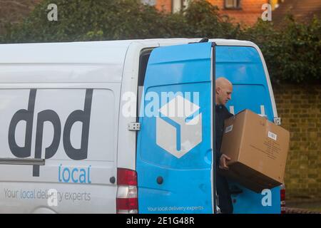 London, Großbritannien. Januar 2021. Ein lokaler DPD-Lieferer hält eine große Kiste, während er aus seinem Lieferwagen kommt, um die Artikel an einen Kunden in London zu liefern. Kredit: SOPA Images Limited/Alamy Live Nachrichten Stockfoto