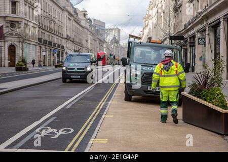 London, Großbritannien. Januar 2021. Ein Arbeiter, der die hohe sichtbare Uniform trägt, sieht, wie er entlang der Regent Street spazierengeht.Englands dritte nationale Sperre tritt legal in Kraft. Kredit: SOPA Images Limited/Alamy Live Nachrichten Stockfoto