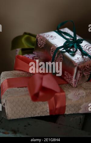 Weihnachtsgeschenke eingewickelt mit Schleifen und Metallic-Papier Stockfoto