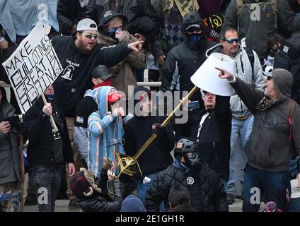 Januar 2021, Washington, District of Columbia, USA: Washington, DC - 010620 EIN Mann, der ein Schild mit der Aufschrift "Make Guillotines Great Again" schwingt, zeigt sich anderen Trump-Anhängern gegenüber, während andere eine Lampe mit der Hand hoben, ein Teil der Möbel, die sie am 6. Januar 2021 aus dem US-Kapitol entfernt hatten. Dies war an einem Tag, an dem sich Tausende von Pro-Trump-Anhängern am 6. Januar 2021 im District of Columbia (DC) außerhalb des US State Capitol versammelten, als der US-Senat die Wahl des Electoral College bescheinigte, mit der Joe Biden als Präsident der USA ratifiziert wurde. (Bild: © Essd Stockfoto