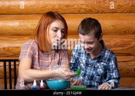 Chemie-Ausbildung und Studienkonzept. Nahaufnahme Mutter und ihr Sohn nehmen die geformte Gelee aus dem Behälter mit einem grünen chemischen Element, ex zu führen Stockfoto