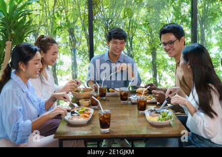 Ein glücklicher asiatischer Freund, der im Restaurant gegessen hat. Gruppenfreund fröhliche Kumpels lachen beim Essen Spaß haben zusammen sitzen im Restaurant essen Tisch Stockfoto