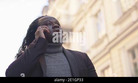 afroamerikanischer schwarzer Mann mit Telefongespräch auf der Stadtstraße. Erfolgreicher Mann auf Ohone-Anruf. Hochwertige Fotos Stockfoto