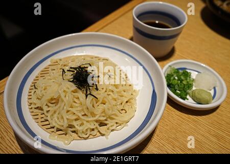 Nahaufnahme Zaru Soba, japanische kalte Buchweizennudeln, serviert mit Dip-Sauce und Belägen Stockfoto