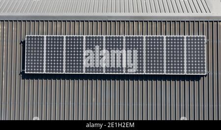 Ansicht von oben nach unten der häuslichen Solarpanel-Installation auf grau Wohndach aus Metall Stockfoto