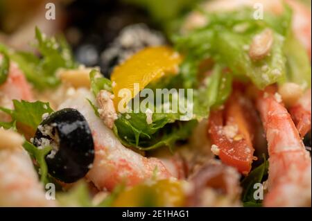 Gemüsesalat mit Garnelen und Pinienkernen auf einem Teller. Hausgemachtes Essen. Nahaufnahme Stockfoto