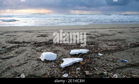 Entsorgter Polystyrol-Kunststoff an schmutziger Ozeanküste nach Seesturm, Sonnenuntergang Zeit Stockfoto