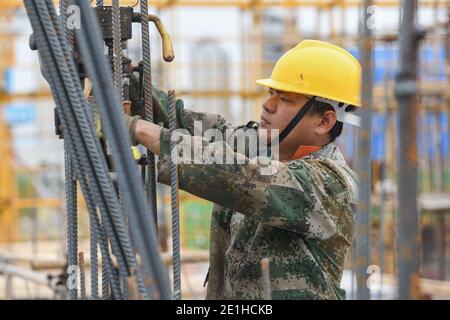 Sanya, Chinas Provinz Hainan. Januar 2021. Ein Arbeiter arbeitet auf einer Baustelle in der Wissenschafts- und Technologiestadt Yazhou Bay in Sanya, südchinesische Provinz Hainan, 5. Januar 2021. Die Wissenschafts- und Technologiestadt soll dem Bau des Freihandels-Hafens Hainan technologische Impulse verleihen. Quelle: Zhou Jiayi/Xinhua/Alamy Live News Stockfoto