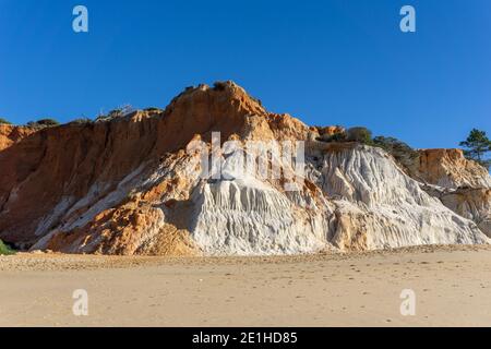 Ein Blick auf einen weiten leeren goldenen Sandstrand mit Bunte Sandklippen an einem sonnigen Tag Stockfoto