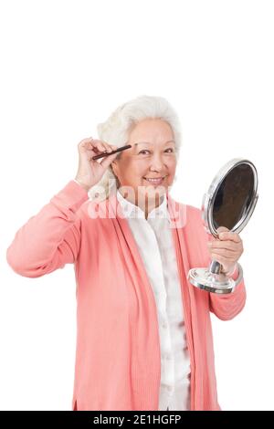 Eine glückliche alte ältere Frau hält Spiegel hochwertige Foto Stockfoto