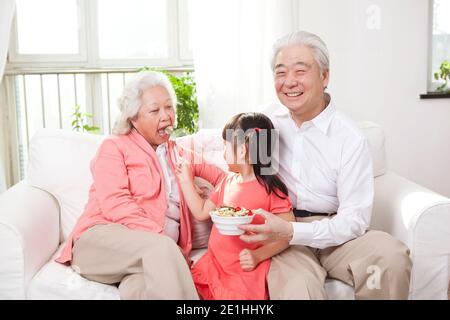 Glückliche Großeltern und Enkelkinder spielen im Wohnzimmer Hochwertige Fotos Stockfoto