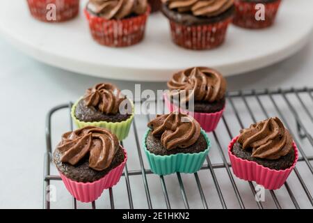 Mini-Schokolade Cupcakes in herzförmigen Silikon Backformen aus nächster Nähe Auf Kühlregal Stockfoto