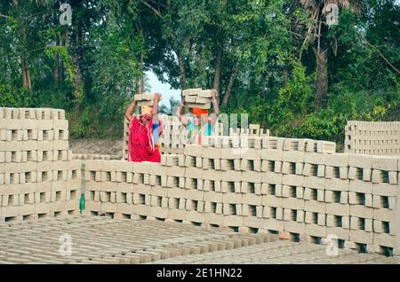 Bild eines Ziegelofens im abgelegenen Hooghly-Viertel. Erwachsene Arbeiter arbeiten hart, um die rohen Ziegel im Ofen zu backen. Stockfoto