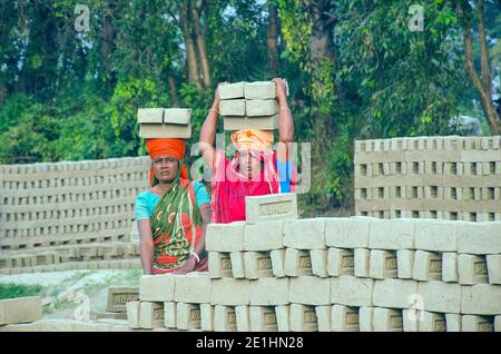 Bild eines Ziegelofens im abgelegenen Hooghly-Viertel. Erwachsene Arbeiter arbeiten hart, um die rohen Ziegel im Ofen zu backen. Stockfoto