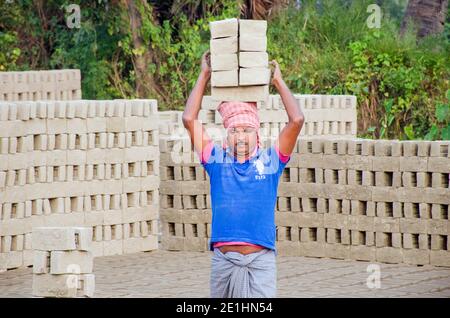 Bild eines Ziegelofens im abgelegenen Hooghly-Viertel. Erwachsene Arbeiter arbeiten hart, um die rohen Ziegel im Ofen zu backen. Stockfoto