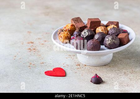 Schokoladentrüffel und Bonbons auf hellem Stein Hintergrund. Hausgemachte dunkle Schokoladentrüffel und Bonbons. Selektiver Fokus. Stockfoto