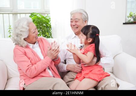 Glückliche Großeltern und Enkelkinder spielen im Wohnzimmer Hochwertige Fotos Stockfoto