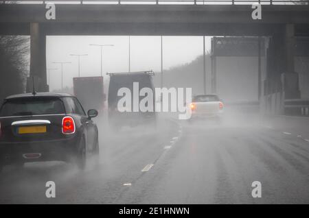 Regen auf der Straße - widrige, neblige und regnerische Fahrbedingungen auf der Autobahn in England Stockfoto