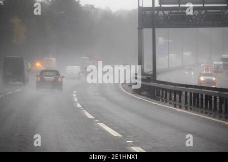 Regen auf der Straße - widrige, neblige und regnerische Fahrbedingungen auf der Autobahn in England Stockfoto