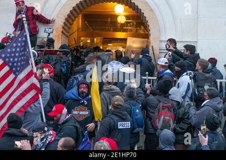 Washington DC, USA. Januar 2021. Randalierer stoßen am 6. Januar 2021 auf die Polizei, die versucht, das Kapitolgebäude durch die Eingangstüren in Washington, DC, zu betreten. Randalierer brachen Fenster und brachen das Kapitolgebäude in einem Versuch, die Ergebnisse der Wahlen von 2020 zu stürzen. Die Polizei benutzte Knöpfe und Tränengasgranaten, um schließlich die Menge zu zerstreuen. Die Randalierer verwendeten Metallstäbe und Tränengas auch gegen die Polizei. (Foto von Lev Radin/Sipa USA) Quelle: SIPA USA/Alamy Live News Stockfoto