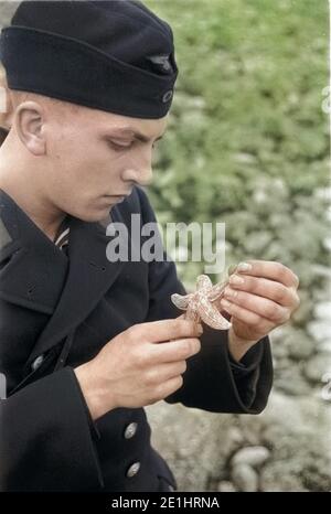 Frankreich - Frankreich in den 1940er Jahren. Le Havre - junge Deutsche Marine sailor mit Seestern. Foto von Erich Andres Essenrode, Matrose mit Seesternen am Strand von Le Havre. Stockfoto