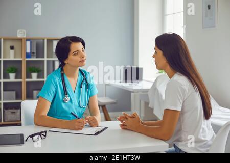 Junge Arzt Therapeut Hören auf Frau Patient in der medizinischen Klinik Stockfoto