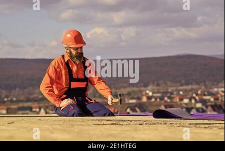 Einbau des Flachdachs. Dachdecker beim Bau eines neuen Dachs. Schätzen Sie den Materialbedarf für Projekte. Installation von Dachmaterialien Wärmedämmung. Man Dachfläche. Professionelles Master Repair Dach. Stockfoto