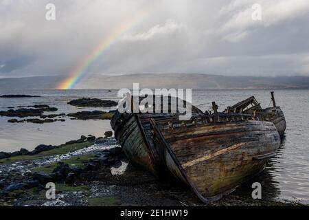 Regenbogen und beached alten hölzernen Fischerboote an der Küste Salen Stockfoto