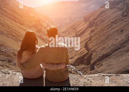 Romantisches Paar in der Liebe Umarmungen und blickt auf tiefen Canyon Zwischen Bergen Blick nach hinten Stockfoto