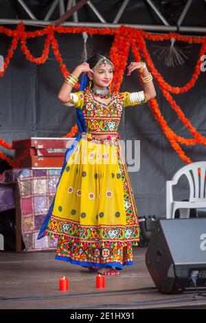 Eine junge Inderin in einem bunten gelben Sari tanzt auf der Bühne während Diwali, dem hinduistischen Festival der Lichter Stockfoto