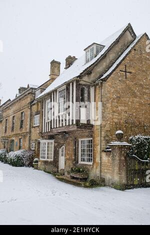 Stein und Fachwerkhaus im Dezember Schnee. Sheep Street, Burford, Cotswolds, Oxfordshire, England Stockfoto