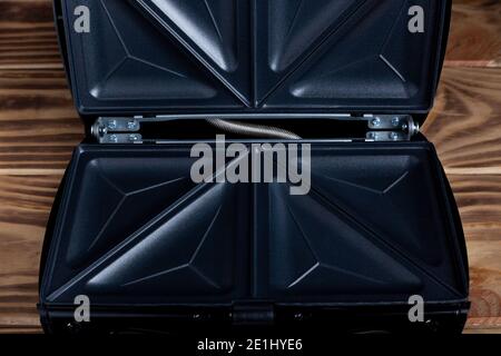 Sandwichmaker für Toast Brot zum Frühstück auf Holz geöffnet Tabelle Stockfoto