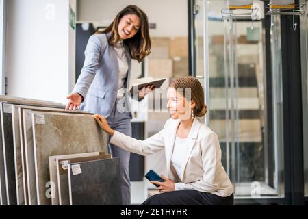Geschäftsfrau, die ein kleines Geschäft im Bad hat. Sie spricht mit einem Kunden, der die Ware wählt. Stockfoto