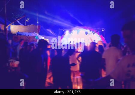 Menge von verschwommenen Menschen im Open-Air-Nachtclub oder Konzert. Unscharfe Fotos mit Bewegungsunschärfe. Leerer Platz für Text, Platz kopieren. Stockfoto