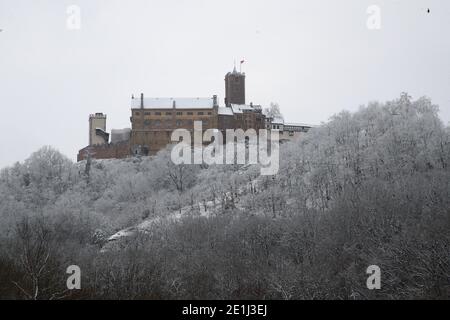 Eisenach, Deutschland. Januar 2021. Mit Schnee bedeckt, ist die Wartburg oberhalb der Stadt zu sehen. Die Stadt gehört zu den am stärksten von Covid-19 betroffenen Städten Thüringens. Kredit: Bodo Schackow/dpa-Zentralbild/dpa/Alamy Live Nachrichten Stockfoto