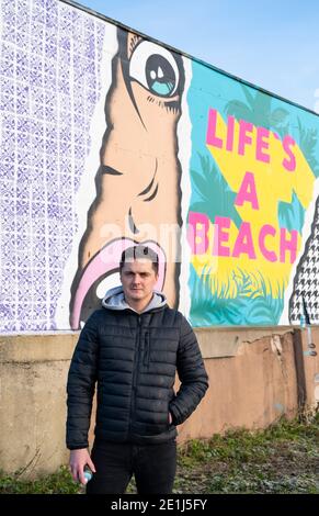 Lancing West Sussex UK 7. Januar 2021 - der Street-Künstler Luke Henley, bekannt als Wooze, hat kürzlich sein neuestes Stück "Life's A Beach" an der Lancing Seafront in der Nähe von Worthing in West Sussex mit dem letzten Schliff ausgestattet. Der Künstler erhielt die Erlaubnis, das Kunstwerk auf einer Wand hinter einer lokalen Garage mit Blick auf Lancing Green zu schaffen und er hofft, dass es die Gegend für Wanderer und Besucher erhellt : Credit Simon Dack / Alamy Live News Stockfoto