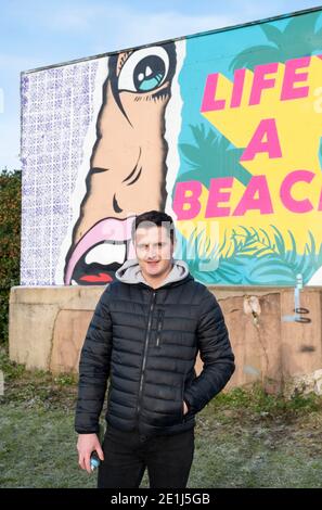 Lancing West Sussex UK 7. Januar 2021 - der Street-Künstler Luke Henley, bekannt als Wooze, hat kürzlich sein neuestes Stück "Life's A Beach" an der Lancing Seafront in der Nähe von Worthing in West Sussex mit dem letzten Schliff ausgestattet. Der Künstler erhielt die Erlaubnis, das Kunstwerk auf einer Wand hinter einer lokalen Garage mit Blick auf Lancing Green zu schaffen und er hofft, dass es die Gegend für Wanderer und Besucher erhellt : Credit Simon Dack / Alamy Live News Stockfoto