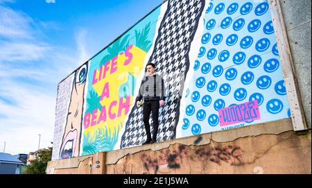 Lancing West Sussex UK 7. Januar 2021 - der Street-Künstler Luke Henley, bekannt als Wooze, hat kürzlich sein neuestes Stück "Life's A Beach" an der Lancing Seafront in der Nähe von Worthing in West Sussex mit dem letzten Schliff ausgestattet. Der Künstler erhielt die Erlaubnis, das Kunstwerk auf einer Wand hinter einer lokalen Garage mit Blick auf Lancing Green zu schaffen und er hofft, dass es die Gegend für Wanderer und Besucher erhellt : Credit Simon Dack / Alamy Live News Stockfoto