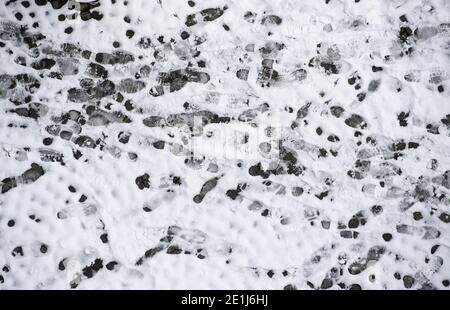 07. Januar 2021, Bayern, München: Auf einem schneebedeckten Bürgersteig kann man zahlreiche Schuhabdrücke in der Innenstadt sehen. Foto: Sven Hoppe/dpa Stockfoto