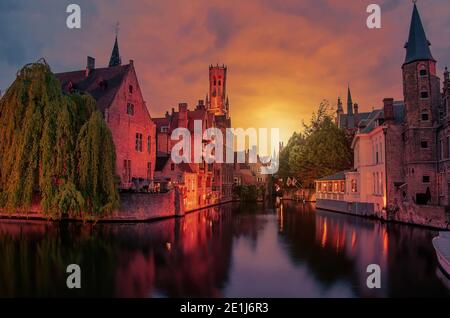 Blick auf den Sonnenuntergang über der Altstadt von Brügge und dem Glockenturm bei Nacht, Brügge, Belgien Stockfoto