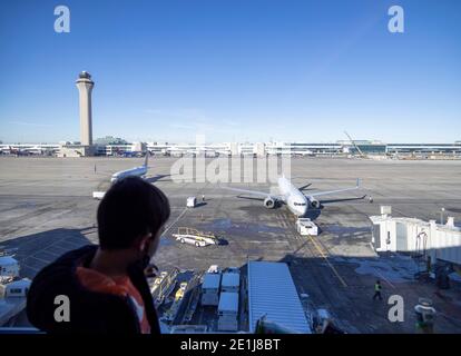 Kleiner Junge, der das Flugzeug aus dem Tor, Denver Flughafen, USA, herausgeschoben hat Stockfoto