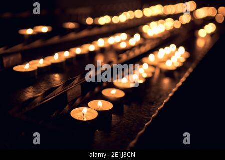 Viele kleine Teelicht-Kerzen leuchten in der Kirche Stockfoto