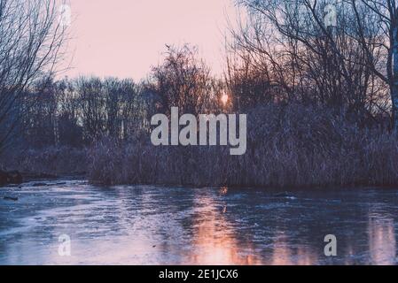 Ein großer gefrorener Teich, ein kleiner gefrorener See, Sonnenuntergang, Eis Stockfoto