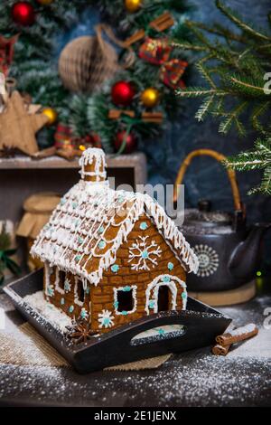 Festliche Weihnachten Styling von hausgemachten Lebkuchen Haus mit Zucker dekoriert Schneeflocken Stockfoto