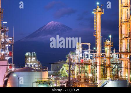 Mt. Fuji, Japan, von hinter Fabriken in der Abenddämmerung gesehen. Stockfoto