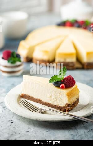 Klassischer New Yorker Käsekuchen mit frischen Beeren auf hellblau Konkreter Hintergrund Stockfoto