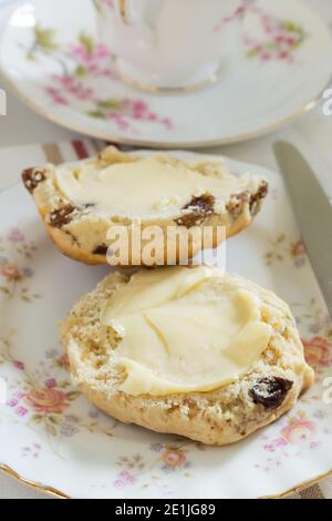 Scones ein klassischer britischer Kuchen gefüllt mit Sultaninen und Rosinen Und wird oft während des Nachmittagstees gebuttert serviert Stockfoto