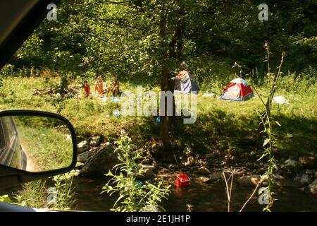 Menschen, die an einem Bach in Rumäniens Landschaft campen Stockfoto